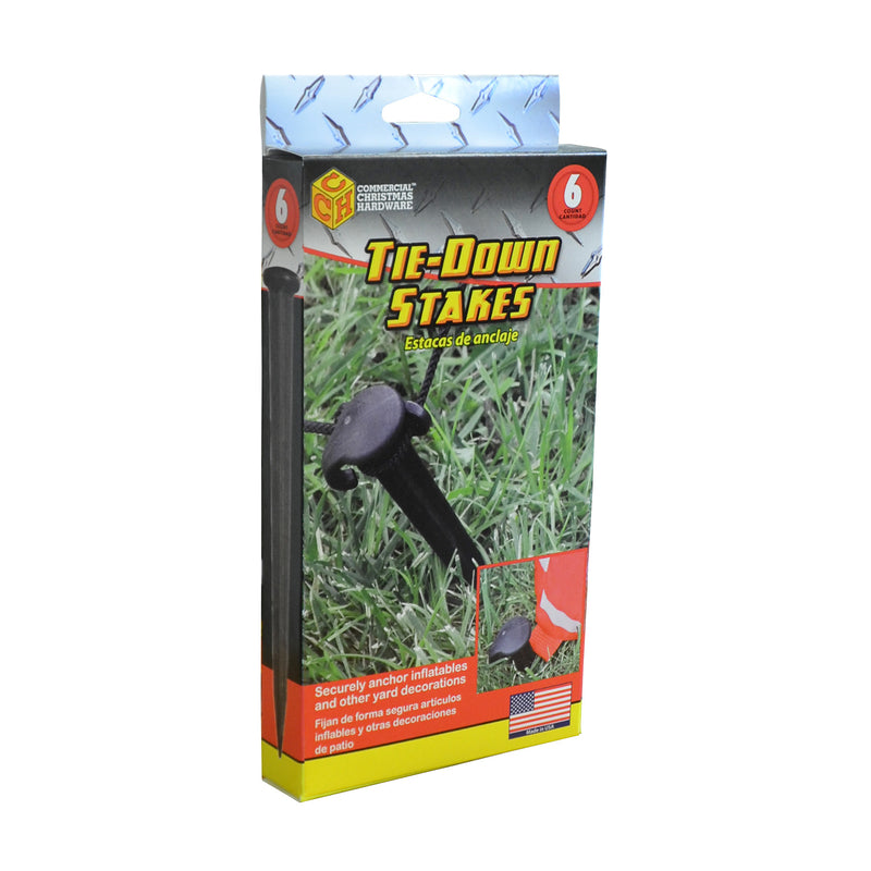 Set of six Emery Jensen tie-down stakes for securing tarps, tents, or outdoor gear, shown in a natural outdoor setting.