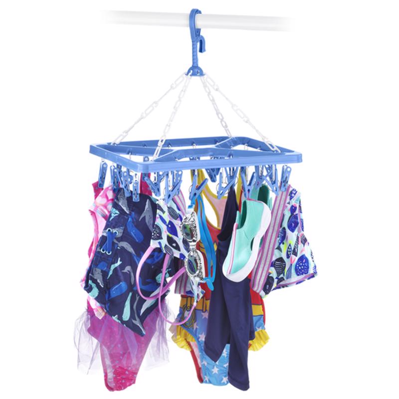 White clip and dry hanger from Emery Jensen for indoor accessories, ideal for hanging clothes and organizing space.